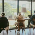 a couple of people sitting at a table in front of a window